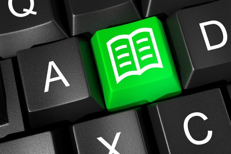 Grüne Taste auf einer Tastatur mit einem offenen Buch-Symbol.
