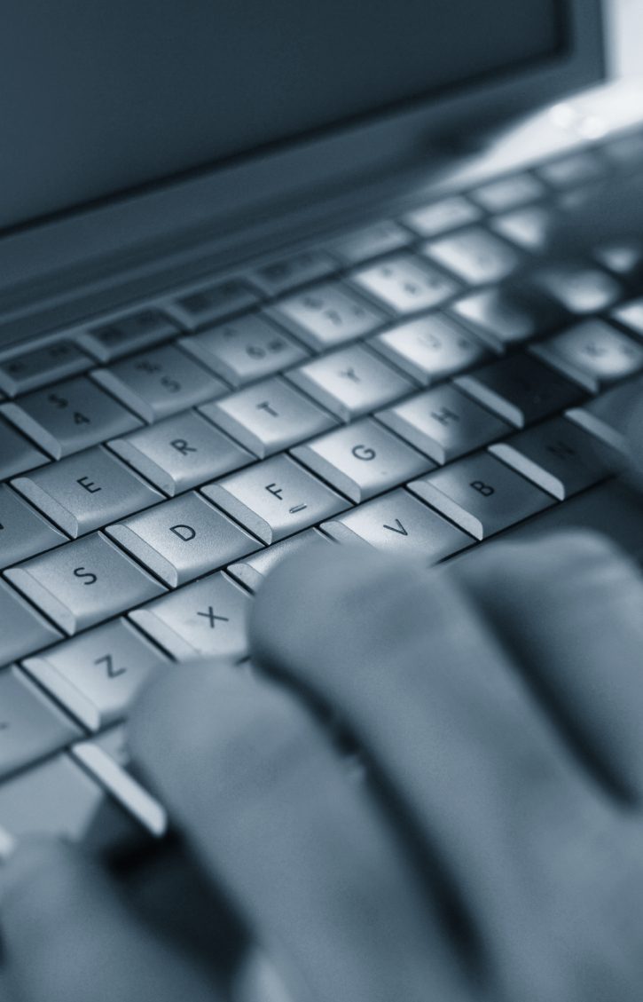 Tastatur Nahaufnahme einer Hand, die über eine Laptop-Tastatur tippt.